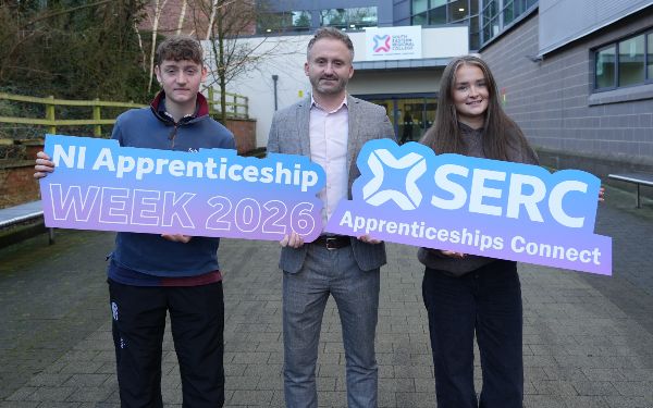 2 apprentices and 1 SERC staff member holding photo props. 